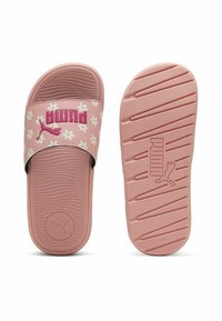 Rozā slīdējošas sandales ar ziedu rakstu un baltu Puma logo. Apakšzolei ir teksturētas rievotas, lai nodrošinātu saķeri. Mīksta putas struktūra komfortam.