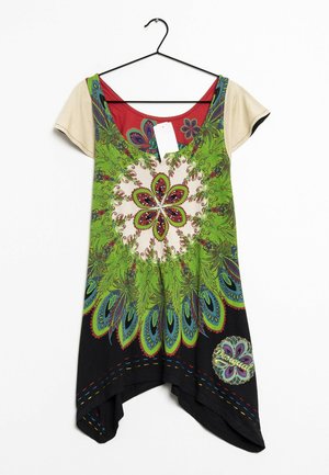 Robe à manches courtes beige sous une robe verte sans manches avec un grand motif floral mandala et des détails multicolores, suspendue à un cintre noir.