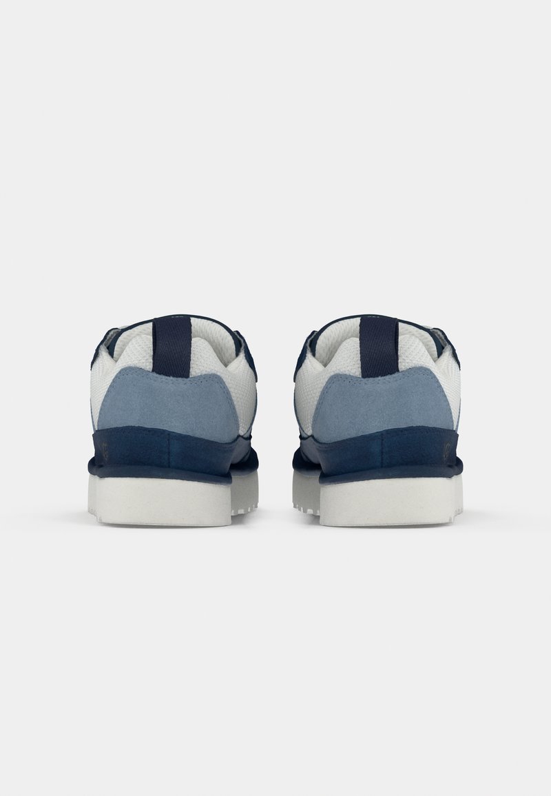 Zapatillas en azul marino y claro con parte superior de malla, acentos de ante, suela blanca plana y bucles en el talón para facilitar su uso.