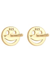 Złote kolczyki w kształcie uśmiechniętej buźki, wykonane z srebra 925, z wyciętymi oczami i ustami oraz małymi, szczegółowymi akcentami.