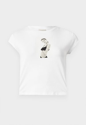 Witte katoenen t-shirt met korte mouwen, voorzien van een zwart-wit fotoafdruk aan de voorkant van een figuur in een zwart outfit.