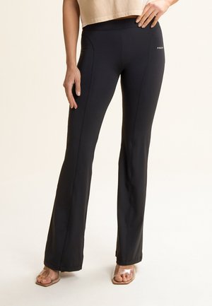 Pantaloni da yoga neri aderenti realizzati in tessuto elastico, con un alto punto vita, cuciture laterali sottili e un design svasato nella parte inferiore.