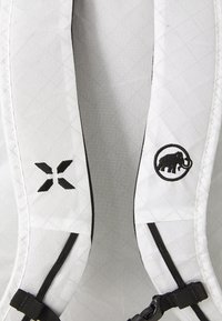 Bretturile rucsacului din textil alb cu model în diamant. Logo-uri negre brodate pe fiecare breteană. Include accesorii negre ajustabile.