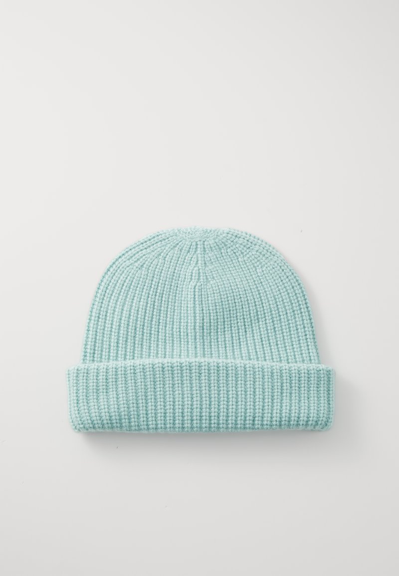 Helle blaue gestrickte Mütze mit umgeschlagenem Saum, die eine gerippte Textur und ein Pompon-Detail an der Oberseite aufweist.
