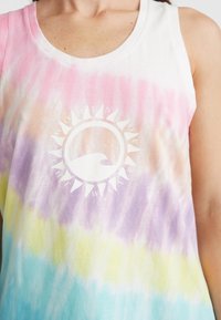 Tanktop med tie-dye i pastellfärger som rosa, lila, gul och blå. Framsidan har en grafik med texten "Women of the Wave" i vitt.