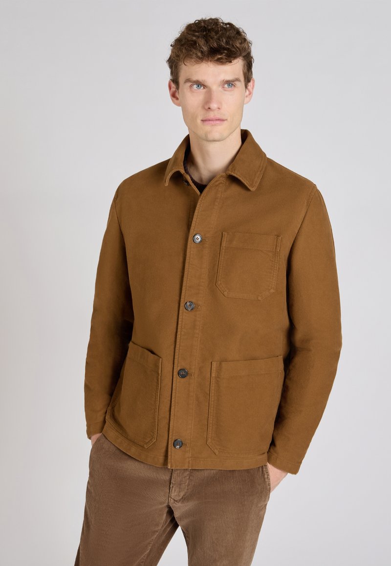 Brązowa bawełniana kurtka z wywijanym kołnierzem, dwoma przednimi kieszeniami oraz zapięciem na guziki. Posiada gładką fakturę i dopasowany fason.