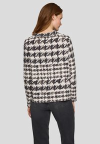 Jacke mit Hahnentrittmuster in neutralen Tönen von Schwarz, Grau und Weiß. Verfügt über eine lockere Passform und lange Ärmel. Glatte Stoffstruktur.