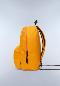 Mochila amarilla con una superficie texturizada, cierre con cremallera y bolsillo lateral. Presenta detalles en marrón, correas ajustables y un diseño compacto.