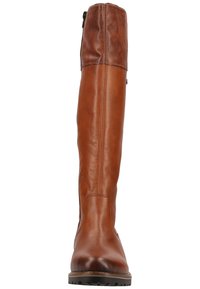 Bottes d'équitation en cuir brun avec une tige haute, une texture lisse, une fermeture éclair latérale et une semelle en caoutchouc plate. Présente des détails de couture contrastés.