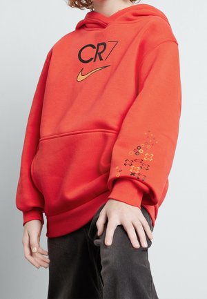Czerwona bluza z kapturem z przednią kieszenią, logo "CR7" i Nike. Na rękawie żółto-czarne graficzne akcenty. Wykonana z miękkiego materiału.