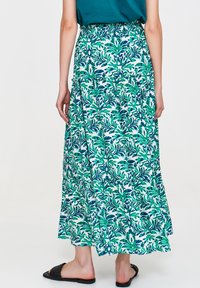 Długa, zwiewna spódnica w zielono-niebieski kwiatowy wzór na białym tle. Posiada elastyczny pas i warstwowy krój.