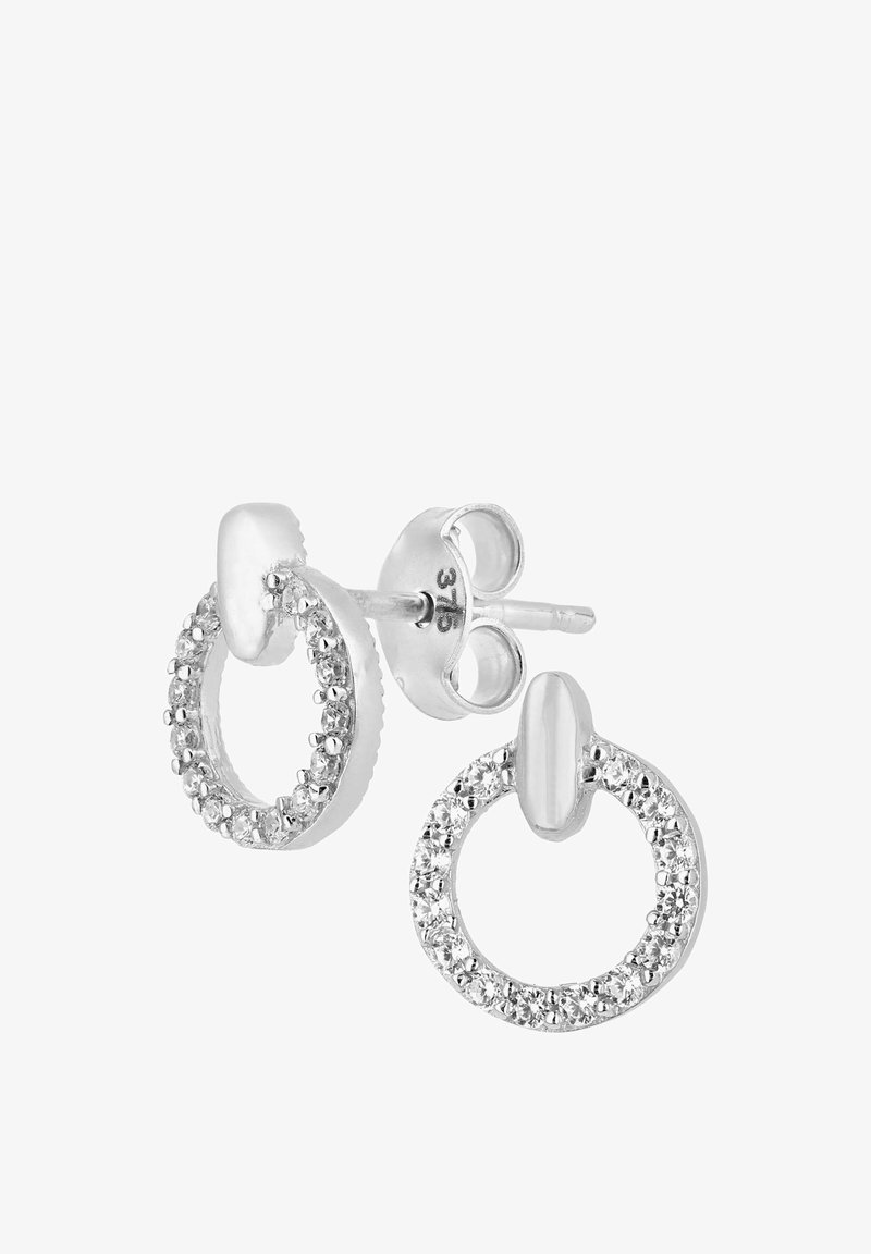 Silverfärgade studs i en cirkulär form med en rad klara stenar runt den yttre kanten och en slät oval accent ovanpå.