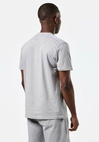 Grå bomull T-skjorte med korte ermer, rund hals og en glatt tekstur. Baksiden har et minimalistisk design uten utsmykninger.