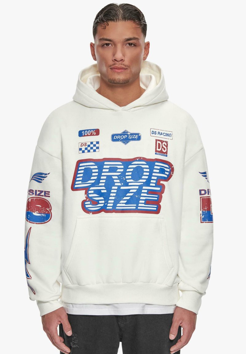 Felpa bianca con cappuccio caratterizzata da una grande grafica "DROP SIZE" blu e rossa, numerosi toppe, tasca frontale e polsini a costine.