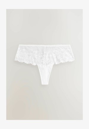 Witte slip met een brede kanten band die bovenaan bloempatronen heeft en een gladde stoffen body.