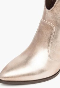 Metallisch bronzene Knöchelstiefel mit spitzem Fuß, glatter Textur, elastischen Seiteneinsätzen und niedrigem, gestapeltem Absatz.