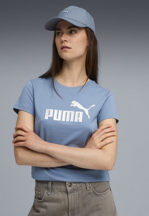 Hellblaue Baumwoll-T-Shirt mit einem weißen "PUMA"-Logo und einer springenden Puma-Grafik. Kombiniert mit einer passenden hellblauen Cap. Lässige Passform.