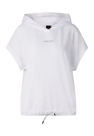 Kobieta ubrana w dużą białą bezrękawnikową bluzę z kapturem, czarne spodenki kolarskie, czarne skarpetki, czarne trampki i duże lustrzane okulary przeciwsłoneczne, stoi na białym tle.