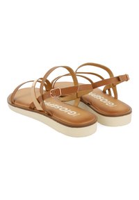 Sandalias de plataforma marrones con múltiples tiras transparentes, correa ajustable en el tobillo y suelas de goma texturizadas. Nombre de la marca impreso en las plantillas.