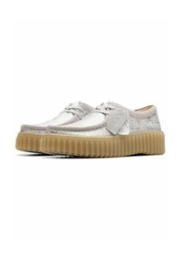 Silver woven shoes with a low-cut design, light gray accents, and a thick, textured beige sole. Features traditional laces and side detail.