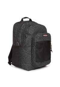 Mochila de cuadros negros con dos compartimentos principales, un bolsillo de malla frontal y correas acolchadas. Presenta el logo de Eastpak en el frente.