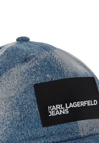 Farmer sapka fekete, téglalap alakú folttal, fehér "KARL LAGERFELD JEANS" felirattal; világoskék, koptatott farmer mintázattal.