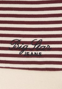 Bordo ir kremu dryžuotas audinys su tamsiai mėlynu šioje vietoje išsiuvinėtu "Big Star" virš "JEANS". Minkšta tekstūra su raukšlėta apatine dalimi.
