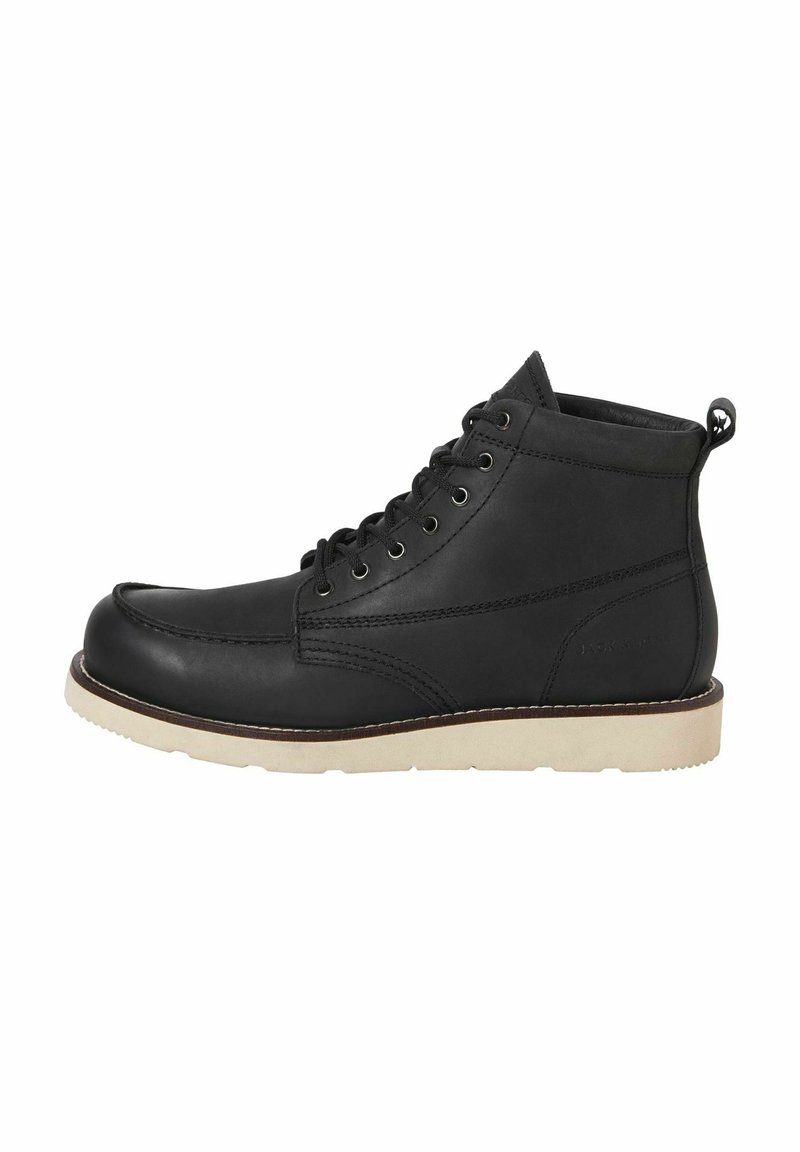 Botines de cuero negro con diseño de cordones, suela de goma de color claro, punta redondeada y un pequeño lazo en la parte trasera para facilitar su uso.