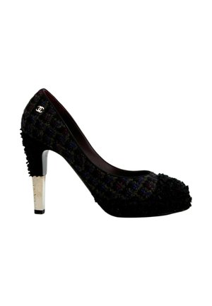 Chaussure à talon haut noire avec tissu texturé, talon argenté et petit logo blanc près de la cheville côté extérieur.