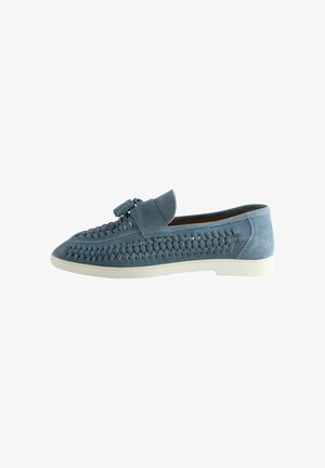 Sinised seemisnahast slip-on-tüüpi kingad, mille külgedel on kootud nahast detailid ja valge kummist tald.