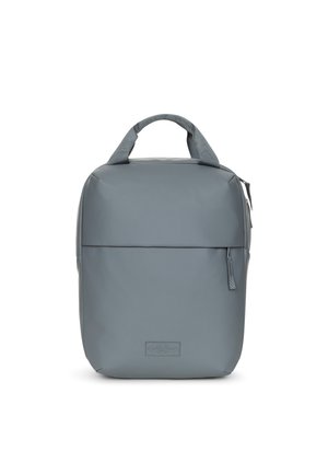 Sac à dos gris en matériau lisse et durable. Doté d'une poignée supérieure, d'une poche zippée à l'avant et d'un design rectangulaire épuré avec une marque discrète.