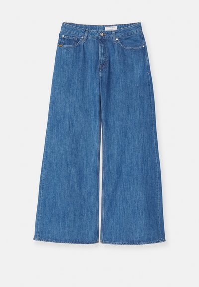Jeans de mezclilla azul de pierna ancha con una cintura alta, líneas limpias y un desvanecimiento sutil. Presenta un diseño estándar de cinco bolsillos y cierre de botón.