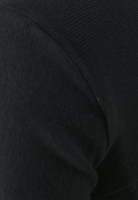 Svart, rippet stoff som viser en teksturert overflate med en glatt finish. Materialet har en svak glans når det belyses.