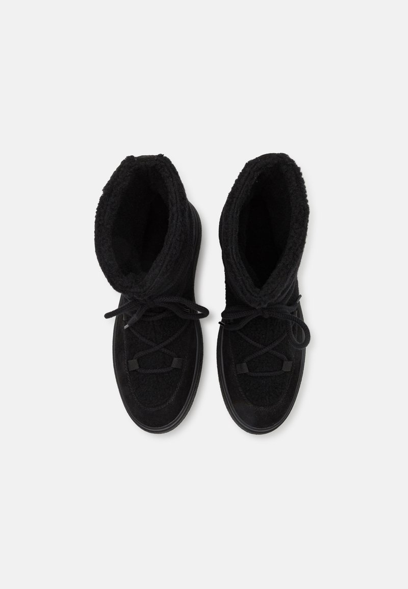 Schwarze Knöchelstiefel mit einem strukturierten, flauschigen Innenfutter, Schnürung vorne und glattem Obermaterial. Verfügt über eine abgerundete Zehenpartie und eine flexible Sohle.