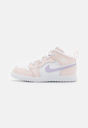 Zapatilla de corte medio con suela blanca, superposiciones en rosa pastel, base blanca y el logo Nike en color lavanda, mostrada de perfil sobre un fondo blanco.