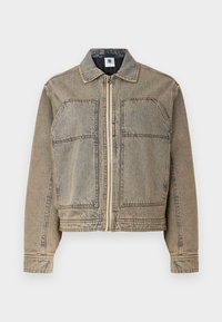 Denim jacket in light brown, featuring a zip closure, two chest pockets, and a structured silhouette with contrasting stitching.