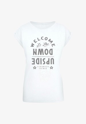 Valge lühikese varrukaga T-särk, millel on graafiline print tekstiga "TERE TULEMAST ÜLESAL ANGLE", halli värvi ja dekoratiivsete elementidega.