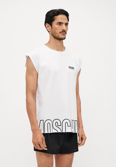 White cotton sleeveless t-shirt with black "Moschino" logo at the chest and large text along the bottom. Features a loose fit and round neckline.