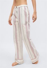 Ελαφρύ, ριγέ παντελόνι πιτζάμας σε κρεμ απόχρωση, με κάθετες μπλε και κόκκινες ρίγες, ελαστική μέση και φαρδιά, ρέουσα πόδια.