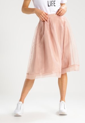 Knee-length pink tulle skirt with a layered design, paired with a white T-shirt and white sneakers. Sheer and lightweight texture.