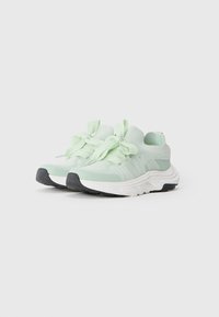 Light green athletic shoes with a textured mesh upper, wide laces, and a chunky white midsole. Black rubber outsole for traction.