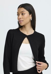 Schwarze Strickjacke aus weichem Strickstoff, mit Rundhalsausschnitt, offenen Vorderseite und einem einzigen Knopfverschluss sowie gerippten Saumdetails.