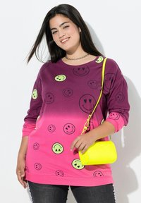Pitkähihaisen gradient-sweatshirtin violetti-pinkki yhdistelmä vihreillä hymyilevillä kasvoilla. Yhdistettynä tekstuuriseen kirkkaan keltaiseen olkalaukkuun.