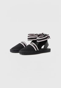 Sandale espadrile negre cu superior din material textil, bot rotund și bretele în jurul gleznei cu dungi negre și roz. Design din iută împletită cu călcâi deschis.