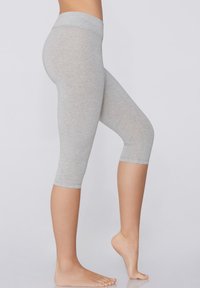Jasnoszare legginsy capri wykonane z miękkiego, elastycznego materiału. Posiadają szeroki pas i dopasowany krój, a nogawki kończą się poniżej kolana.