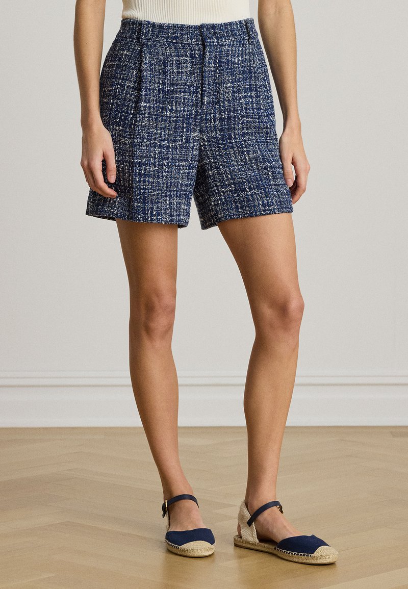 Σορτς από βελούδινο ύφασμα σε ναυτικό μπλε χρώμα με λευκές κηλίδες, διαθέτουν ψηλή μέση, πιέτες και χαλαρή γραμμή. Συνδυάζονται με ναυτικά espadrilles.