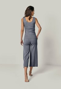 Gray knit tank top and matching cropped pants, featuring a fitted design with subtle ribbing and soft texture, viewed from the back.