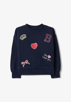 Felpa blu navy con toppe rosa e rosse che includono una corona, un cuore, un fiocco, la lettera B e il testo "Hey ti amo."