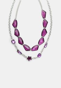 Lilla ædelstenshalskæde med sølvkæde, der har facetterede sten i forskellige former, herunder ovale og hexagonale, arrangeret i to niveauer.