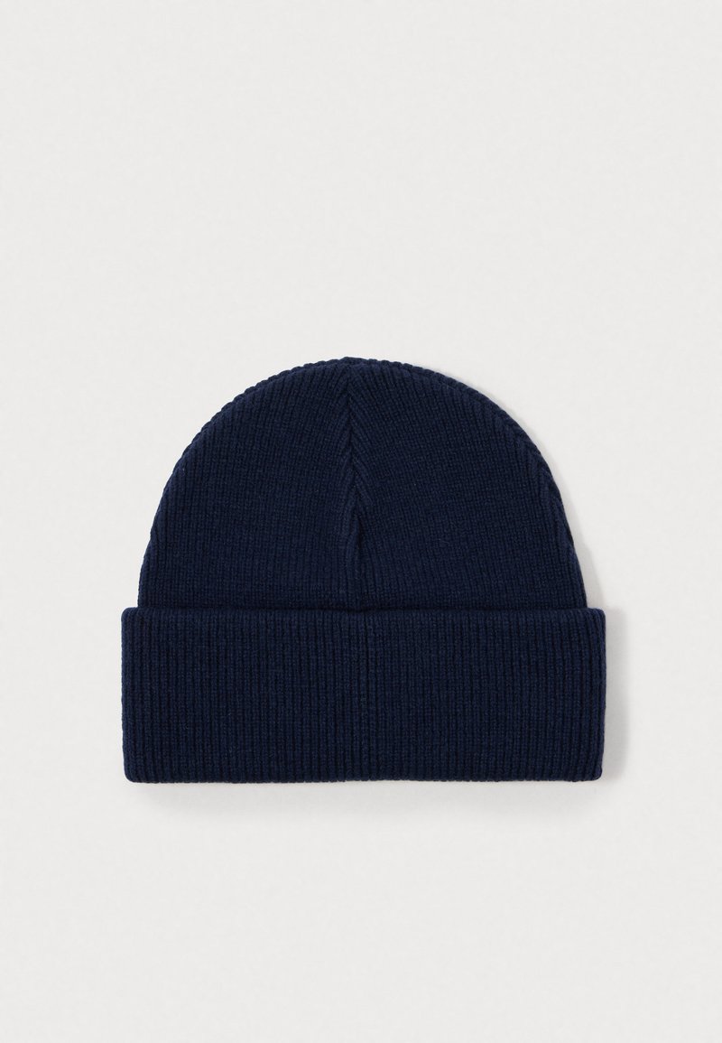 Berretto a maglia blu navy, con una texture a coste, cima arrotondata e risvolto, realizzato in un materiale morbido e elastico.